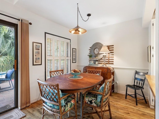 dining space featuring baseboards, light wood-style floors, and a healthy amount of sunlight