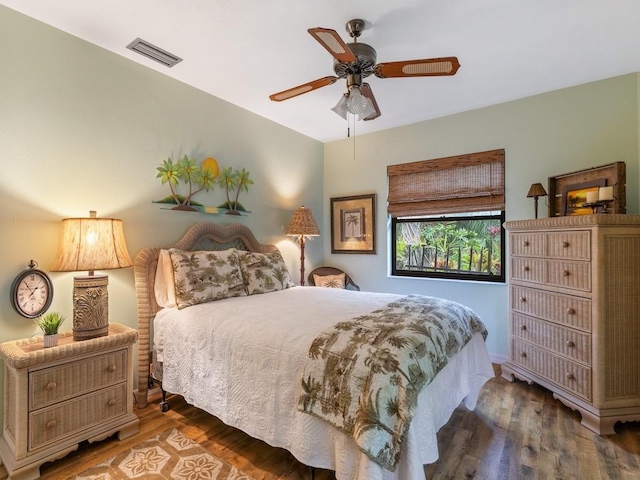 bedroom featuring dark wood-style floors, ceiling fan, and visible vents