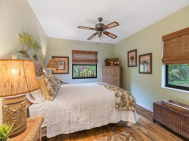 bedroom with a ceiling fan, baseboards, and wood finished floors