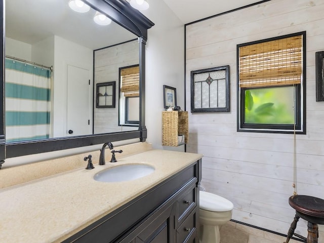 full bathroom featuring toilet, wooden walls, vanity, a shower with curtain, and tile patterned floors