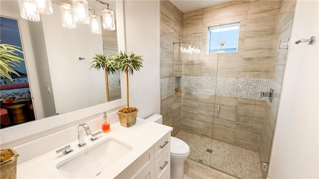 bathroom with a shower with shower door, vanity, and toilet