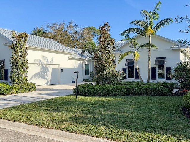 view of front of home with a garage and a front lawn