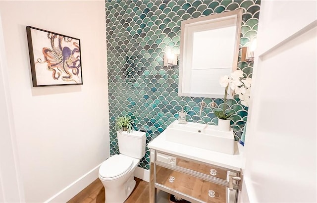 bathroom with hardwood / wood-style flooring, toilet, and vanity