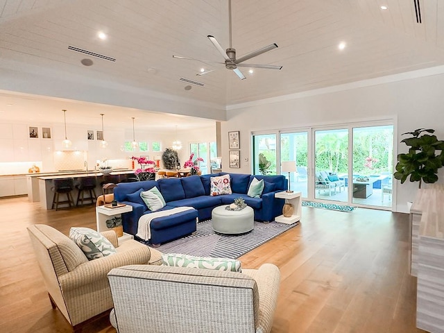 living room with ceiling fan, light hardwood / wood-style flooring, and wooden ceiling