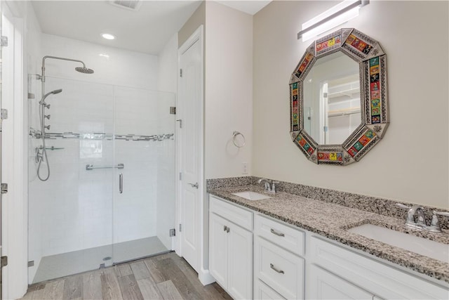 bathroom with vanity, a shower with door, and wood-type flooring