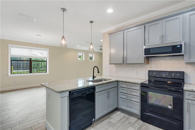 kitchen with kitchen peninsula, hanging light fixtures, black appliances, sink, and tasteful backsplash