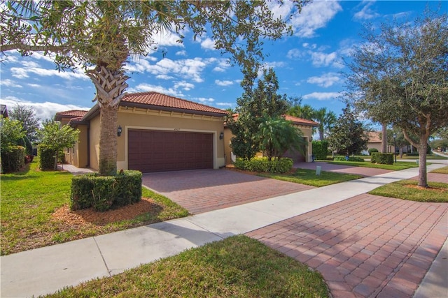 mediterranean / spanish-style house featuring a front yard and a garage