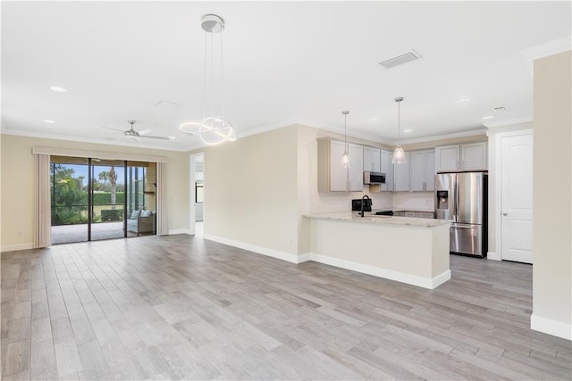 kitchen featuring appliances with stainless steel finishes, light stone counters, pendant lighting, crown molding, and kitchen peninsula