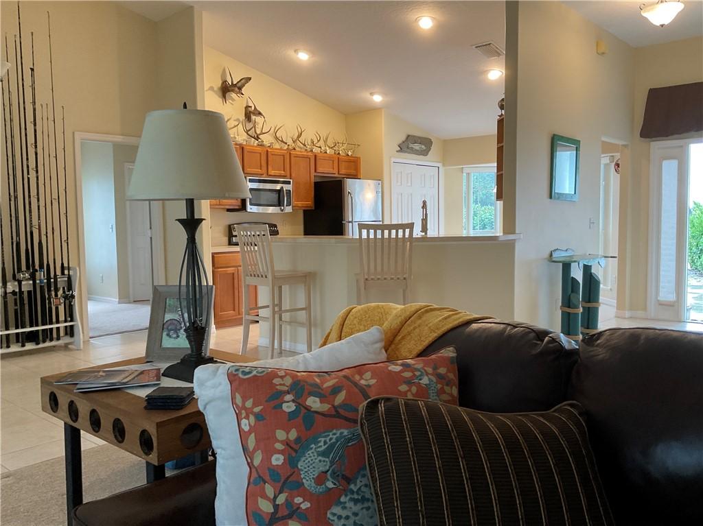 tiled living room featuring plenty of natural light and vaulted ceiling