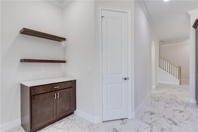 interior space with marble finish floor, stairs, baseboards, and crown molding