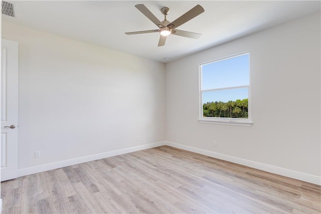 unfurnished room with ceiling fan, light wood-style floors, visible vents, and baseboards