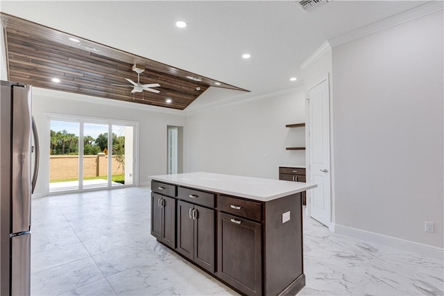 kitchen with marble finish floor, light countertops, a kitchen island, and freestanding refrigerator