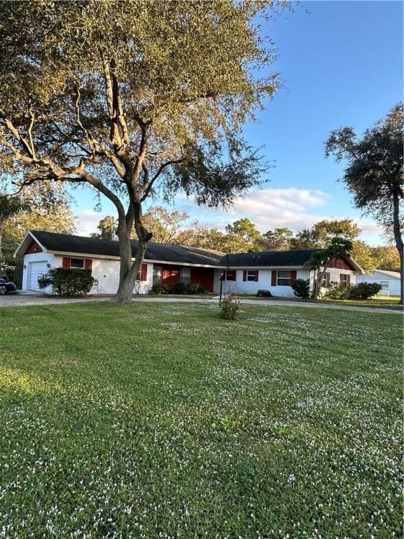 ranch-style house featuring a front yard and a garage