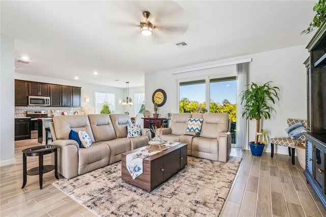 living room featuring ceiling fan and light wood-type flooring