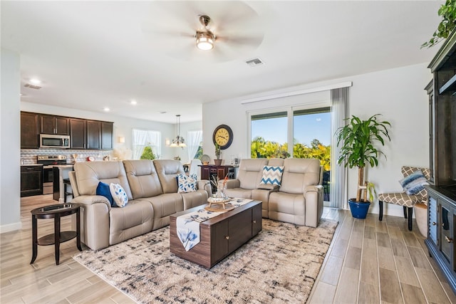 living room featuring a wealth of natural light, ceiling fan, and light hardwood / wood-style flooring