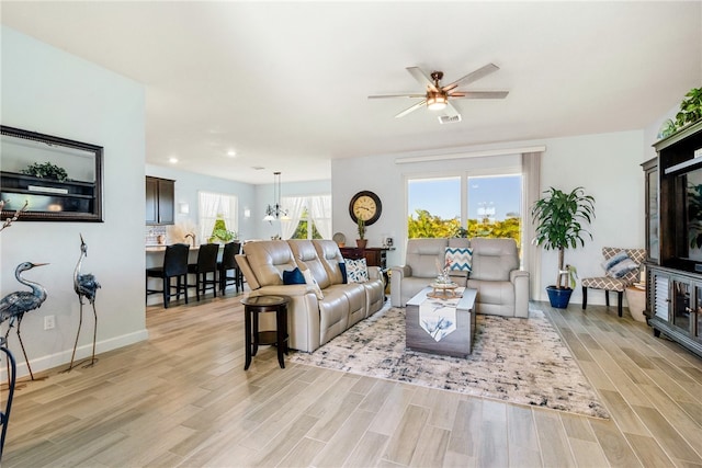 living room with ceiling fan and light hardwood / wood-style flooring