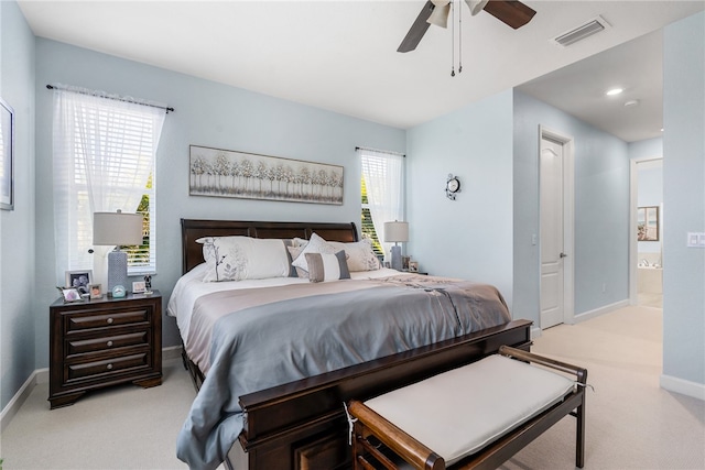 carpeted bedroom with ensuite bathroom and ceiling fan