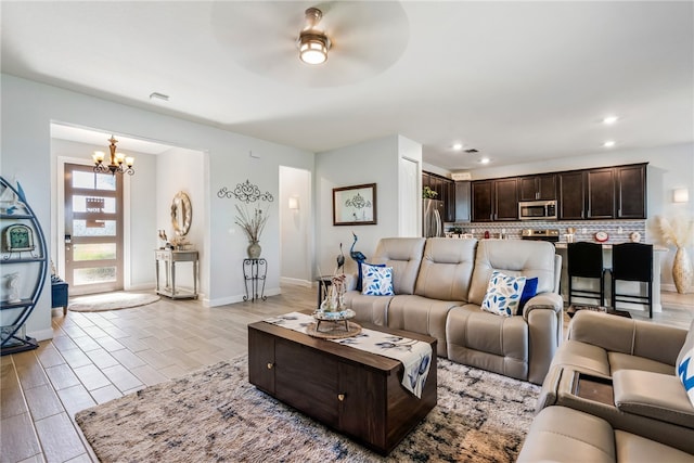 living room with ceiling fan with notable chandelier