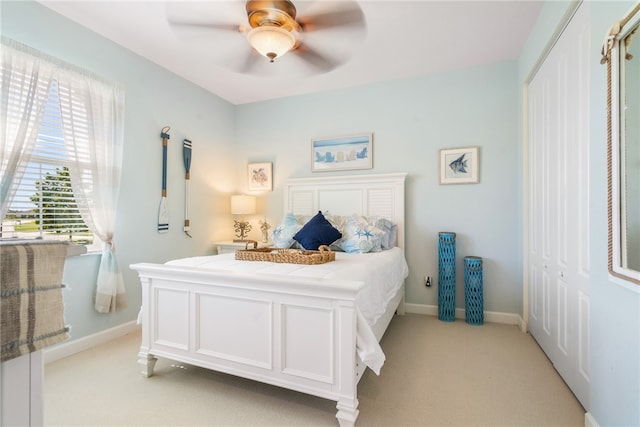 carpeted bedroom featuring ceiling fan and a closet