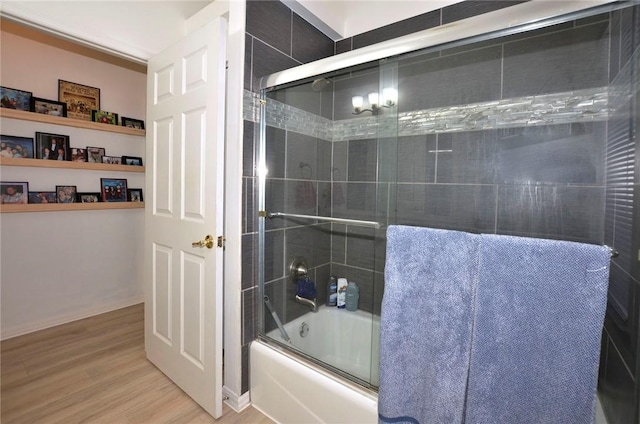 bathroom with hardwood / wood-style flooring and enclosed tub / shower combo