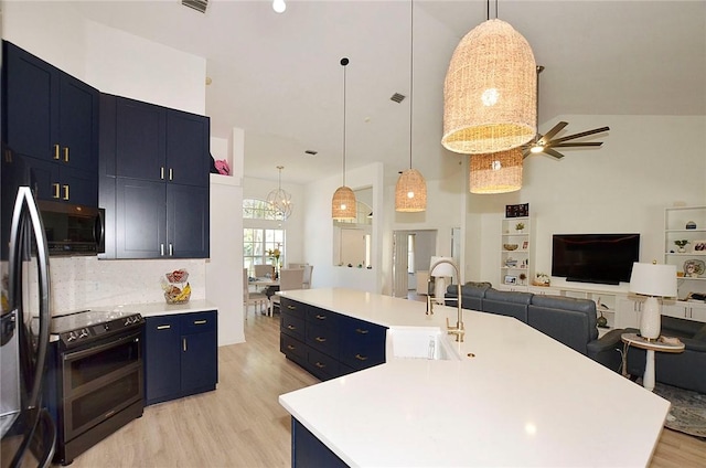 kitchen with pendant lighting, sink, blue cabinetry, electric range, and a spacious island