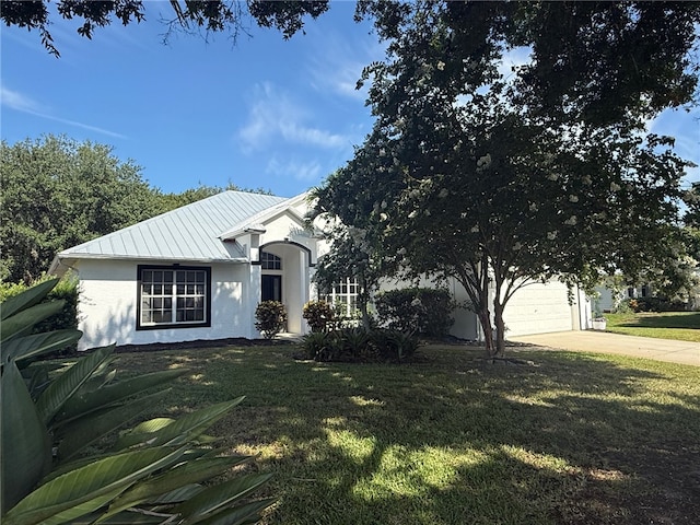 405 29th Ct SW, Vero Beach, FL 32968 - view of front of property with concrete driveway, a metal roof, a front yard, stucco siding, and a standing seam roof