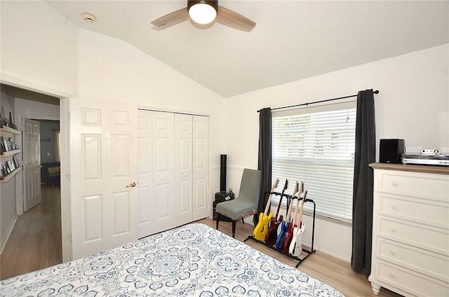 bedroom featuring ceiling fan, lofted ceiling, a closet, and light wood-type flooring