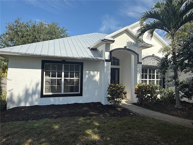 405 29th Ct SW, Vero Beach, FL 32968 - view of home's exterior featuring stucco siding, a metal roof, and a standing seam roof