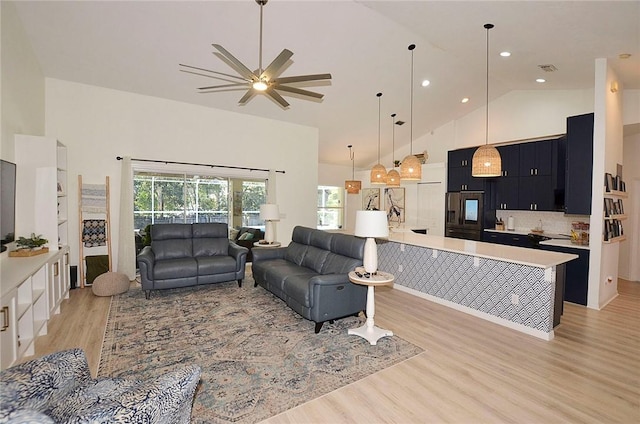 living room featuring high vaulted ceiling, light hardwood / wood-style floors, and ceiling fan