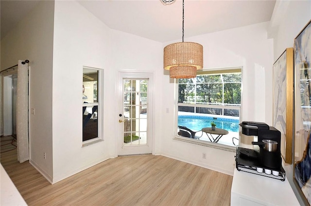 interior space with plenty of natural light, lofted ceiling, and light wood-type flooring