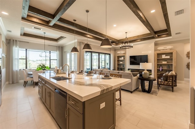 kitchen featuring dishwasher, hanging light fixtures, sink, light tile patterned floors, and a kitchen island with sink