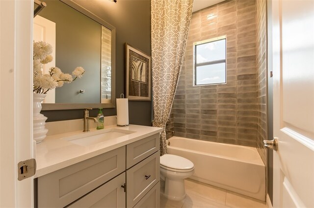 full bathroom with vanity, tile patterned flooring, toilet, and tiled shower / bath combo