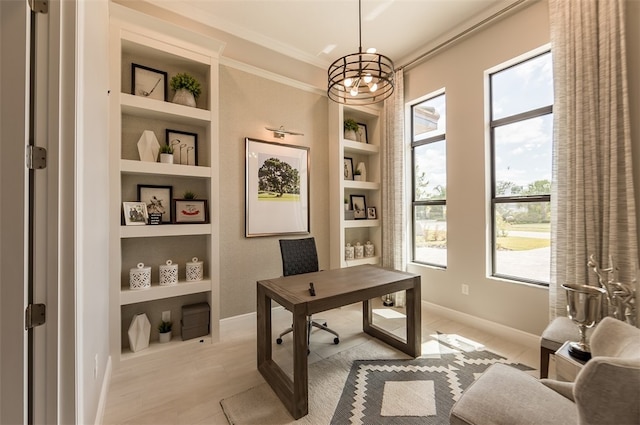 office area featuring plenty of natural light, crown molding, built in features, and an inviting chandelier