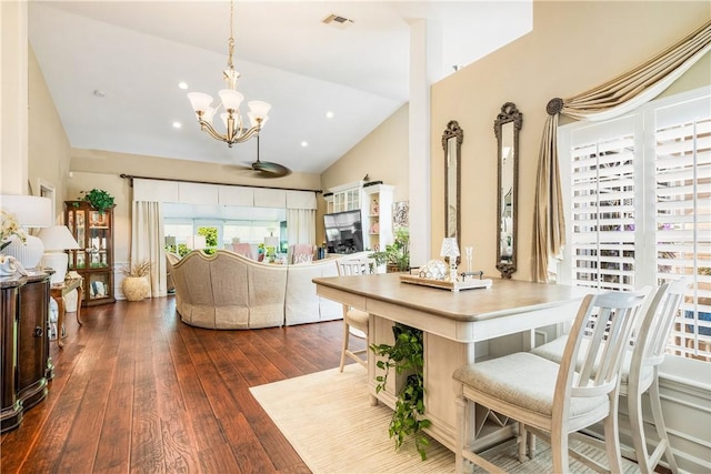 dining space with vaulted ceiling, an inviting chandelier, and dark hardwood / wood-style flooring