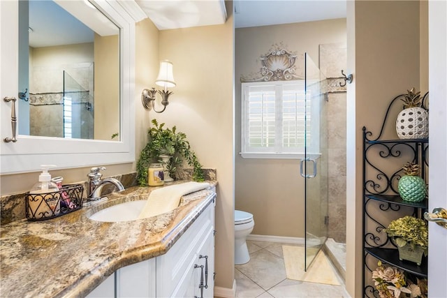 bathroom with vanity, toilet, tile patterned flooring, and a shower with door