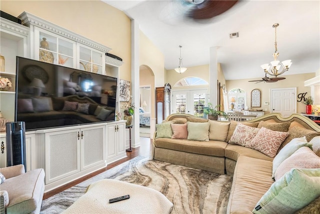 living room featuring french doors, high vaulted ceiling, ceiling fan with notable chandelier, and hardwood / wood-style floors