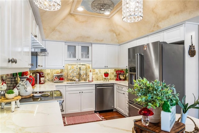 kitchen featuring appliances with stainless steel finishes, sink, white cabinets, exhaust hood, and light stone counters