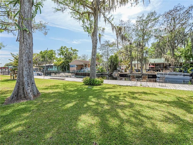 view of community with a lawn and a dock