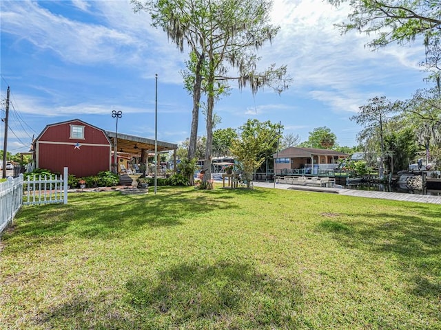 view of yard with an outbuilding, fence, and a barn