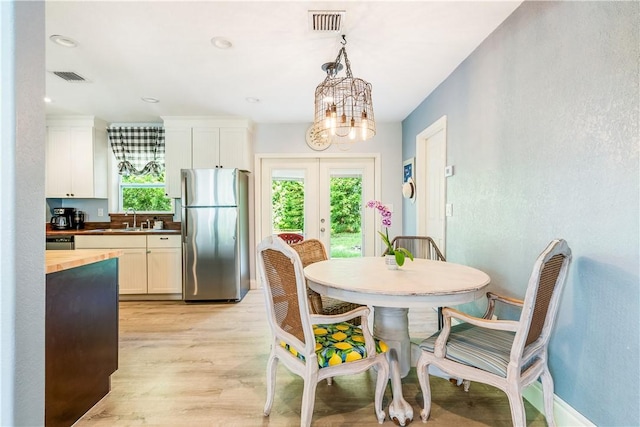 1717 20th Ave, Vero Beach, FL 32960 - dining room featuring french doors, light wood-type flooring, and a chandelier