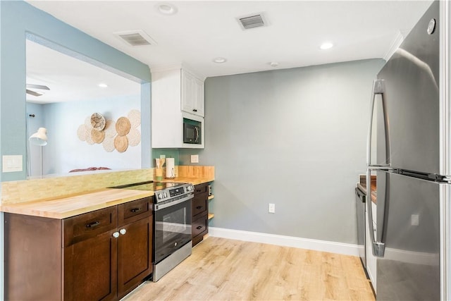 1717 20th Ave, Vero Beach, FL 32960 - kitchen with appliances with stainless steel finishes, white cabinets, light wood-type flooring, dark brown cabinetry, and a peninsula