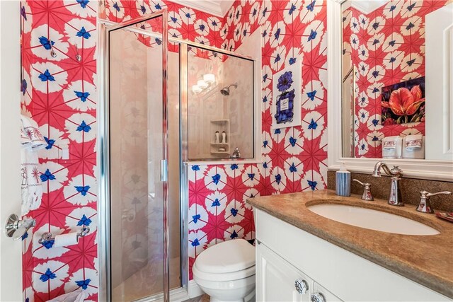 bathroom featuring vanity, toilet, and a shower with door