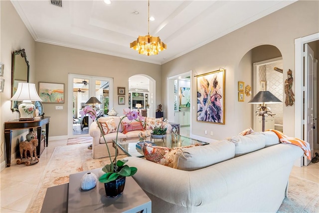 living room featuring a chandelier, light tile patterned floors, a tray ceiling, and ornamental molding