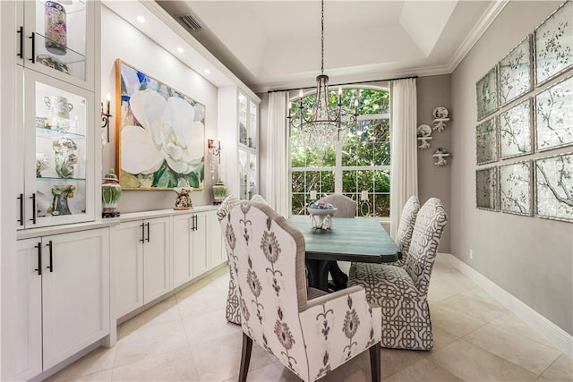 tiled dining room featuring crown molding, a tray ceiling, and a chandelier