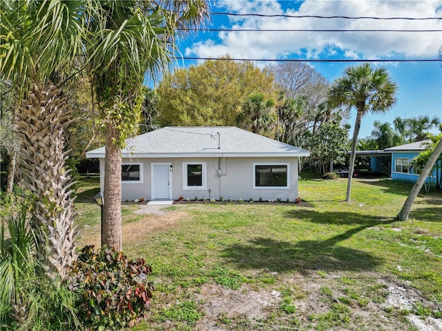 rear view of house featuring a lawn