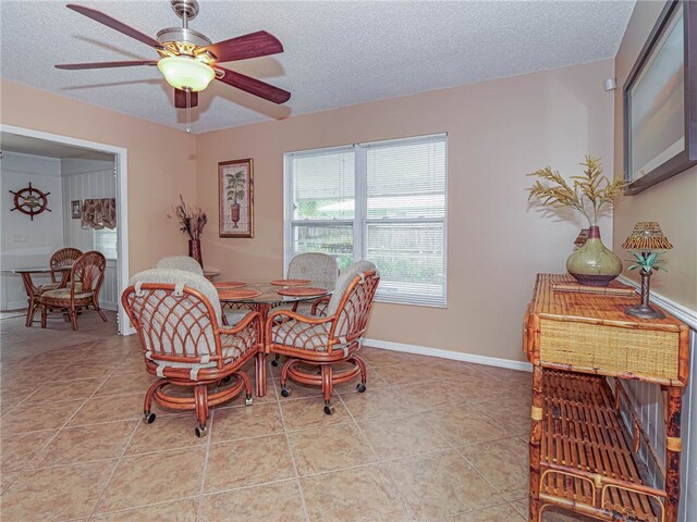 dining room featuring a textured ceiling, light tile patterned floors, and ceiling fan