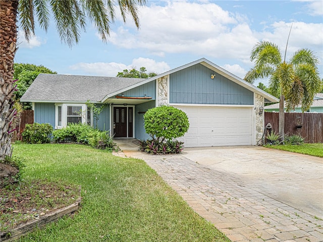 ranch-style home featuring a front lawn and a garage