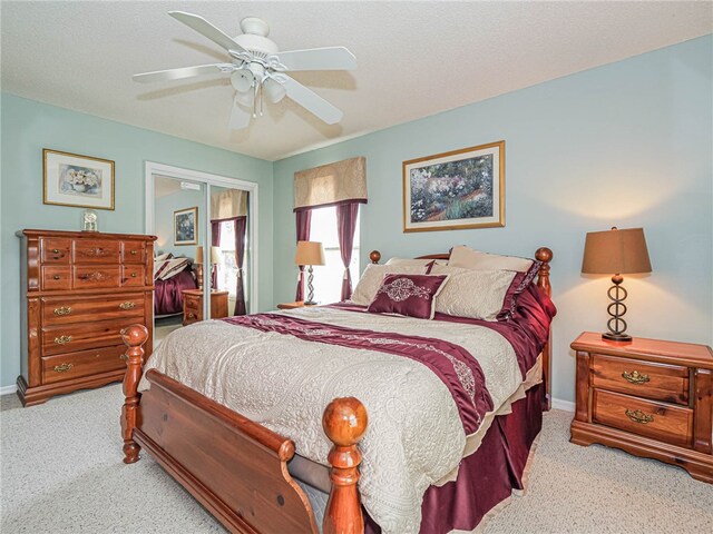 bedroom featuring a closet, light colored carpet, and ceiling fan