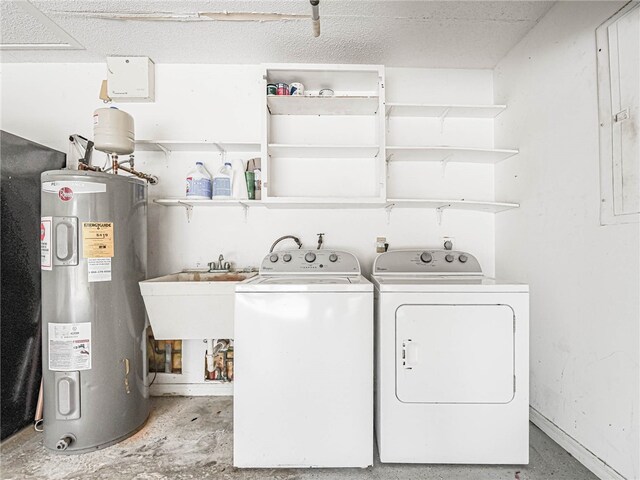 washroom with water heater, sink, and washer and dryer