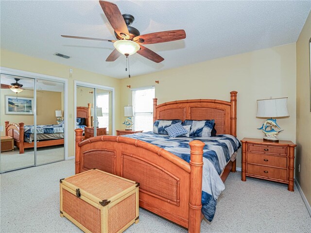 carpeted bedroom with a textured ceiling and ceiling fan